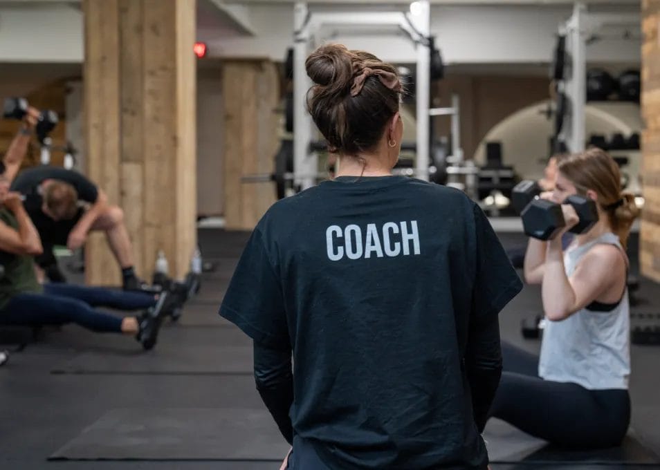 Female trainer watching people exercise